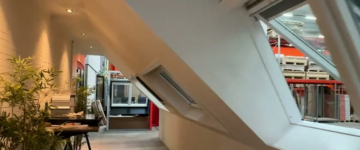 Een lichte showroom met ramen in een schuin dak