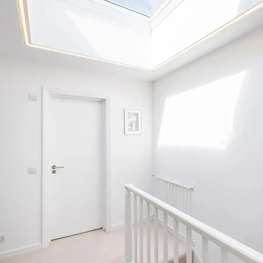 Daglicht valt door een lichtkoepel in een lichte hal